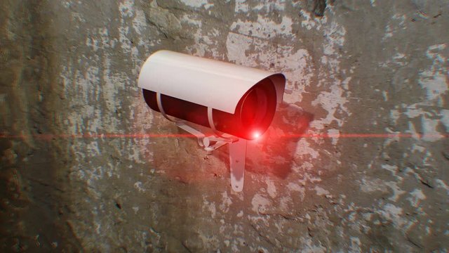 Close up on a security camera attached to a wall. The Security Camera pans left to right and back again, allowing for an infinite loop.