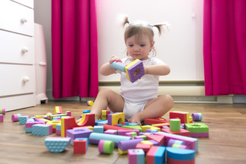 kid girl playing block toys at home