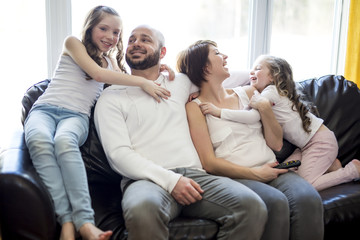 Family sitting in living room watching tv