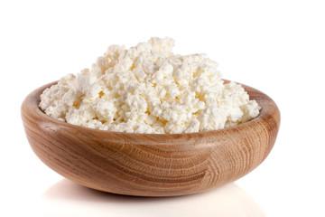 Cottage cheese in a wooden bowl isolated on a white background