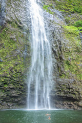 Fototapeta na wymiar A couple enjoying the amazing Hanakapi'ai falls in Kauai island, Hawaii