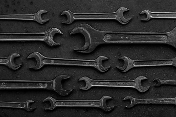 Set of black & white wrenches on black background