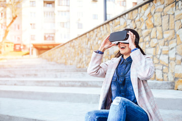 Pretty girl outdoor enjoying virtual reality glasses