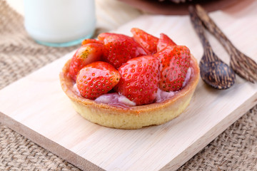 Tart with fresh strawberry on wooden background,