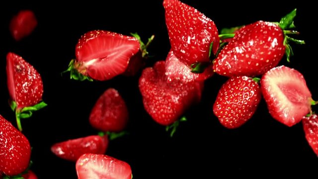 Juicy strawberry flying in the air on a black background