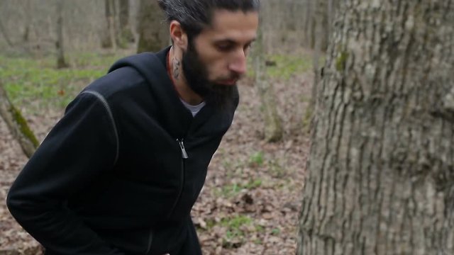 The fighter trains a punch and beats his fists in the tree