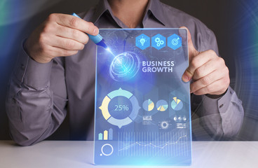 Business, Technology, Internet and network concept. Young businessman working on a virtual screen of the future and sees the inscription: Business growth