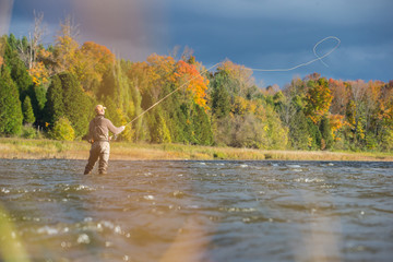 Man fly fishing in the fall in a river