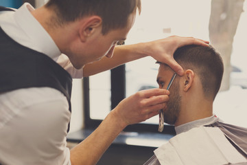 Man getting haircut by hairstylist at barbershop