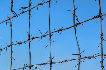 Barbed wire on background sky