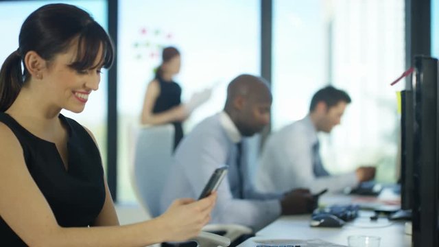  Bored business team in city office using cell phones for personal use