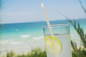citrus cocktail with lemon on the background of a tropical beach 