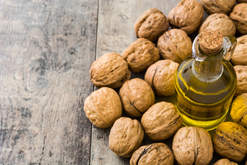 Walnuts oil on wooden background
