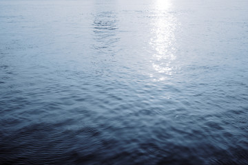 Water surface with ripples and sunlight reflections