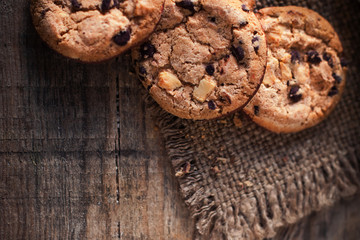 Chocolate cookies on dark  napkin on wooden table. Closeup of a group of assorted cookies..