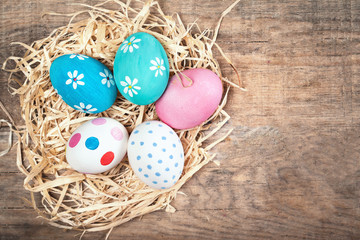 Easter composition with colorful  eggs on wooden background with  space for text
