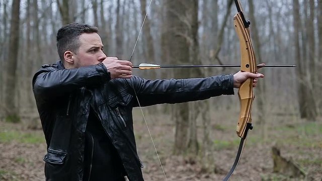 Man shoot with a bow in the forest