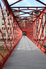 Puente Eiffel peatonal de color rojo, sobre el río Onyar en Girona
