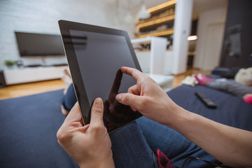Close up and part of human hand using digital tablet on sofa