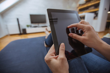 Close up and part of human hand using digital tablet on sofa in living room