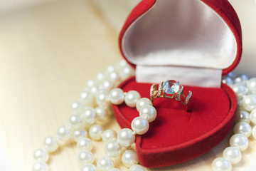 Golden ring with gem and pearls in a red gift box