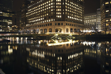 London Night view of skyscrapers in Canary Wharf mirroring in Thames 