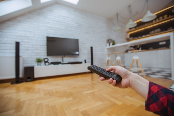 Close up and part of human hand using remote control 