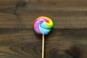 rainbow lollipop on wooden background