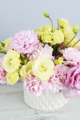Floral arrangement with pink carnation and yellow eustoma flowers.