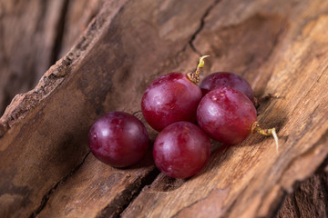 Bunches of fresh ripe red grapes on a wooden textural background
