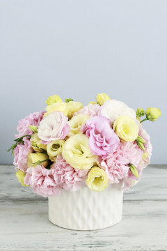 Floral arrangement with pink carnation and yellow eustoma flowers.