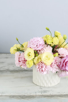 Floral arrangement with pink carnation and yellow eustoma flowers.