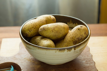 Potatoes and potato sliced on wooden table. Selective focus