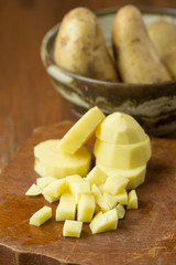 Potatoes and potato sliced on wooden table. Selective focus