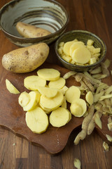 Potatoes and potato sliced on wooden table. Selective focus