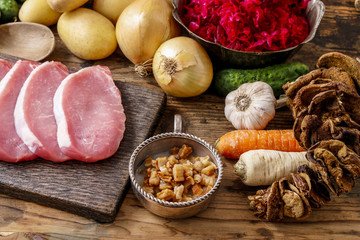Different kinds of meat and vegetables on wooden table.