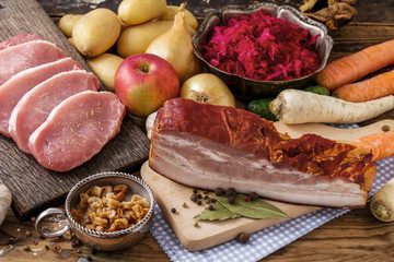 Different kinds of meat and vegetables on wooden table.