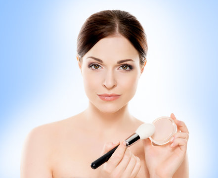 Portrait of young, beautiful and healthy woman: over blue background. Healthcare, spa, makeup and face lifting concept.
