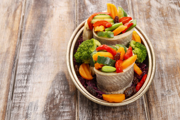 Pickled herring rolls with vegetables.