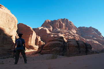 Fototapeta na wymiar Giordania, 2013/03/10: un uomo di spalle guarda il deserto del Wadi Rum, la Valle della Luna simile al pianeta Marte, una valle scavata nella pietra arenaria e nelle rocce di granito