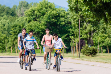 Obraz na płótnie Canvas Family of four on bike tour in summer