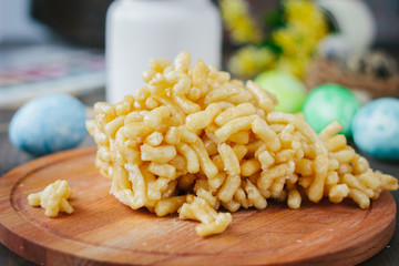 Chak-chak cake over wooden board surrounded by easter eggs.