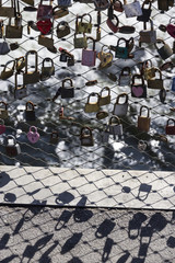 Love locks on a wire mesh fence of a bridge in Graz, Austria