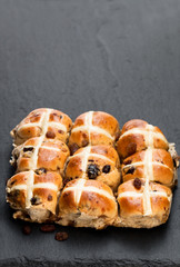 Easter  cross buns and sultanas on black stone background