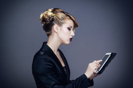 Portrait d'une jeune femme consultant sa tablette tactile