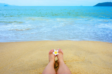 female foot  on the beach, flower