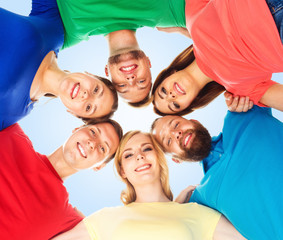 Group of happy students standing together and looking at camera over blue background.  School, university, education, concept.