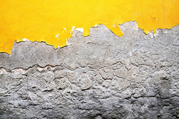 yellow, gray destroyed plaster at a brick wall. Grunge cement, with a shabby paint background.