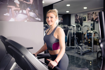 Fototapeta na wymiar Fitness girl running on treadmill