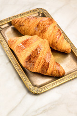 Fresh croissants on vintage tray, with copyspace